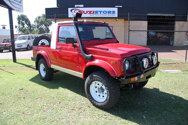 Suzuki Sierra vs Jimny 1 Red Ute Rebuild parked on grass at 4WD Part Shop WA
